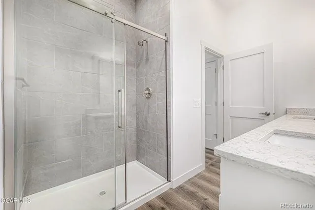 a bathroom with a granite countertop sink and shower