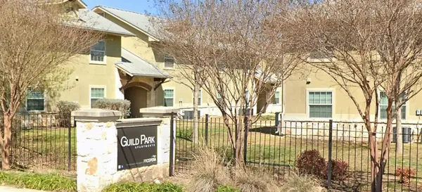 a view of a house with a street sign and a tree