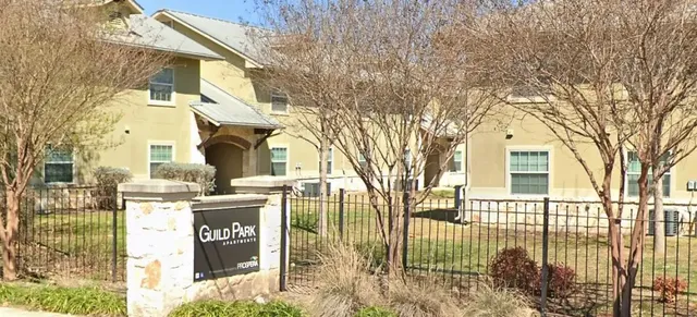 a view of a house with a street sign and a tree