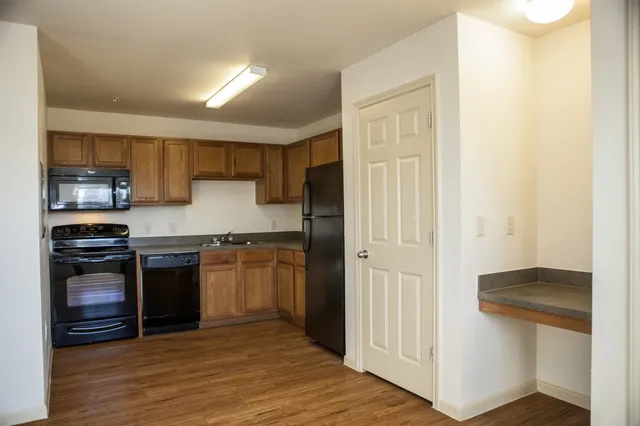 a kitchen with stainless steel appliances granite countertop a refrigerator and a stove top oven