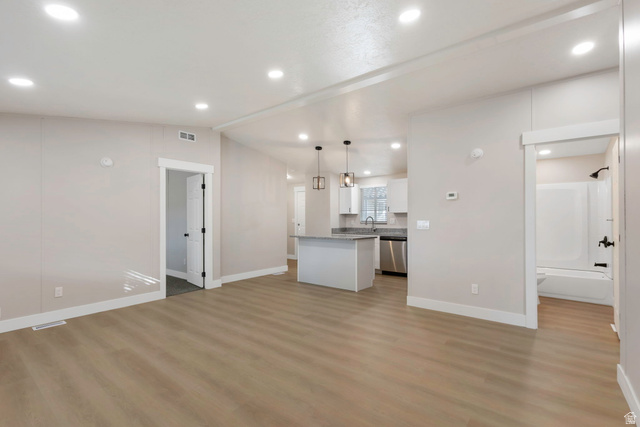 96 Barrington Way Layton, UT 84041 - Photo 28 of 28 Kitchen with white cabinets, lofted ceiling, open floor plan, a kitchen island, and pendant lighting