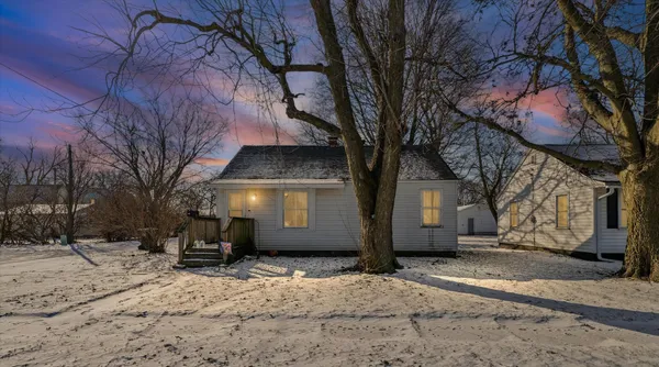 a front view of a house with a yard covered in snow
