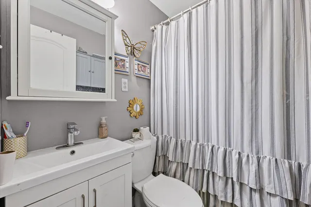 a bathroom with a sink a toilet and shower curtain