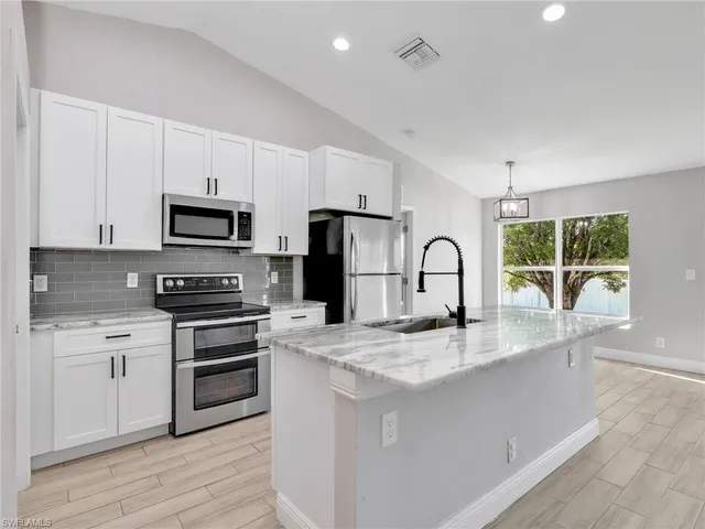 a kitchen with kitchen island a sink and appliances