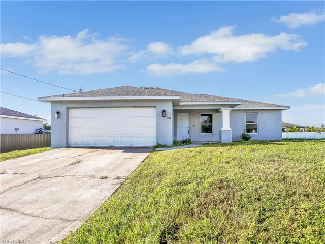 a front view of a house with a garden and yard