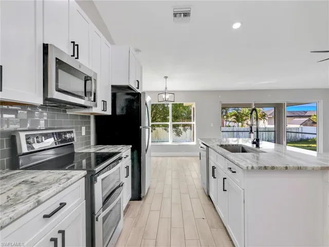 a kitchen with stainless steel appliances granite countertop a sink stove and refrigerator