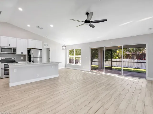 a view of empty room with wooden floor and windows