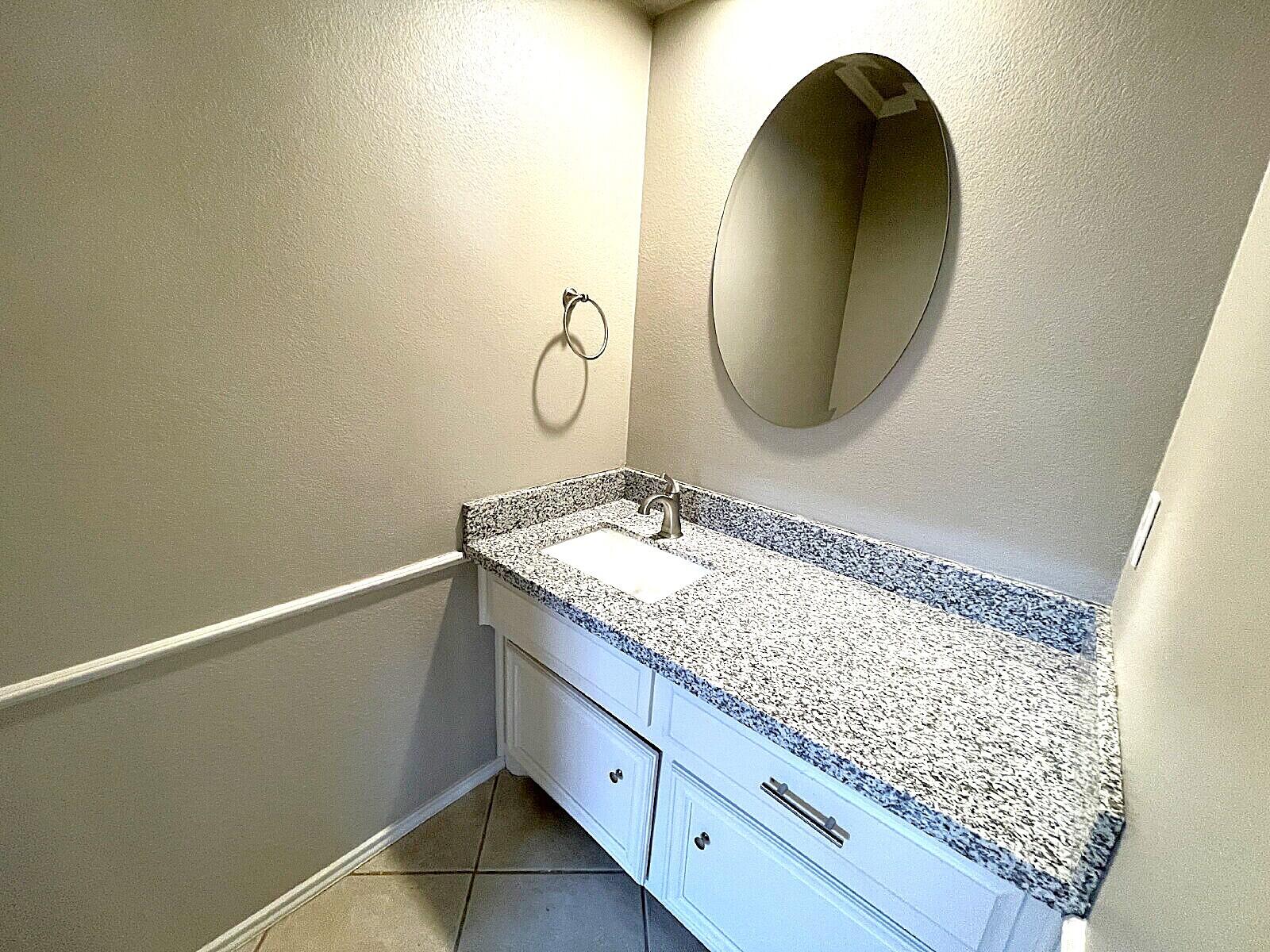 6328 10th Street Lubbock, TX 79416 - Photo 12 of 25 a bathroom with a granite countertop sink and a mirror