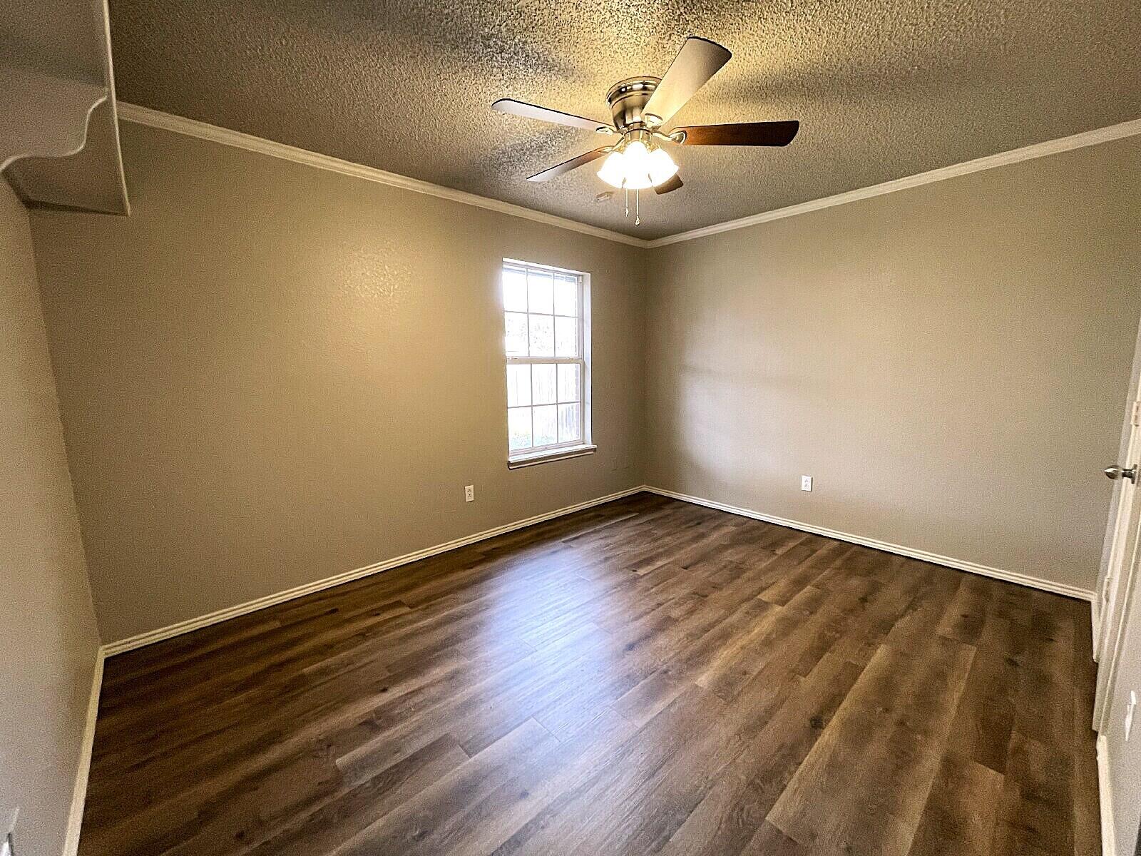 6328 10th Street Lubbock, TX 79416 - Photo 13 of 25 a view of an empty room with wooden floor and a window