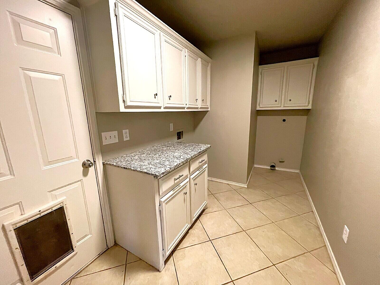 6328 10th Street Lubbock, TX 79416 - Photo 15 of 25 a kitchen with granite countertop white cabinets and white appliances