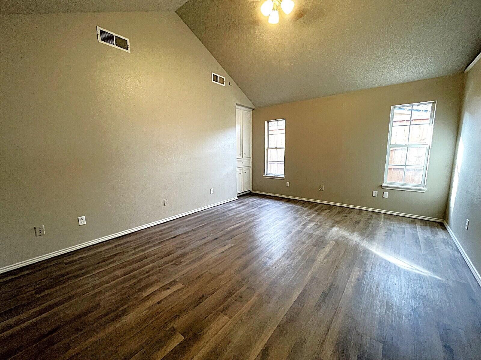6328 10th Street Lubbock, TX 79416 - Photo 16 of 25 an empty room with wooden floor and windows
