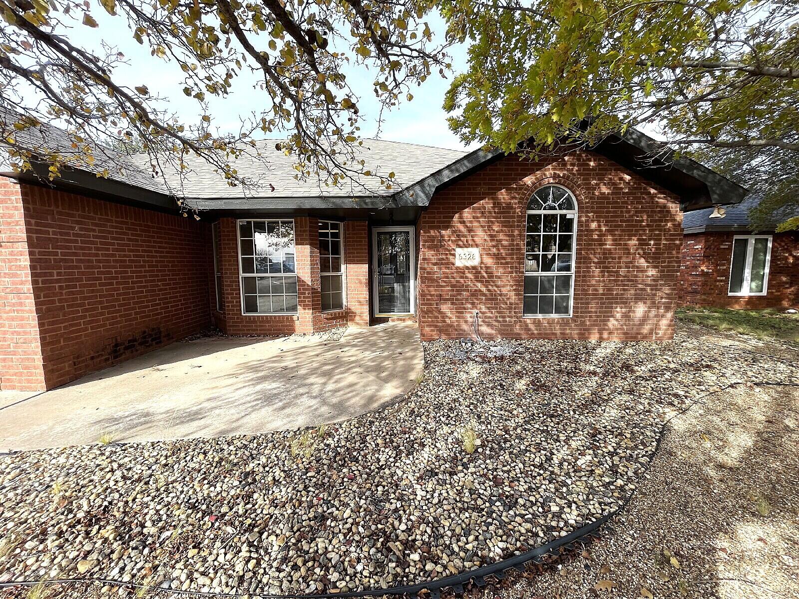 6328 10th Street Lubbock, TX 79416 - Photo 2 of 25 a front view of a house with a yard