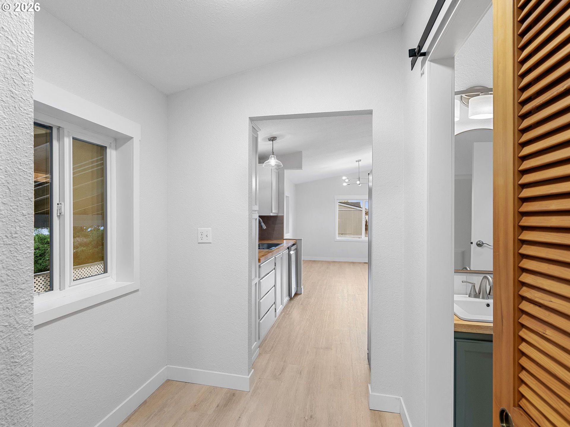 15768 Southeast Powell Boulevard, Unit 12 Portland, OR 97236 - Photo 13 of 31 a view of a hallway with wooden floor and a bathroom