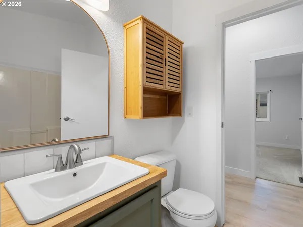 a bathroom with a sink a toilet and mirror