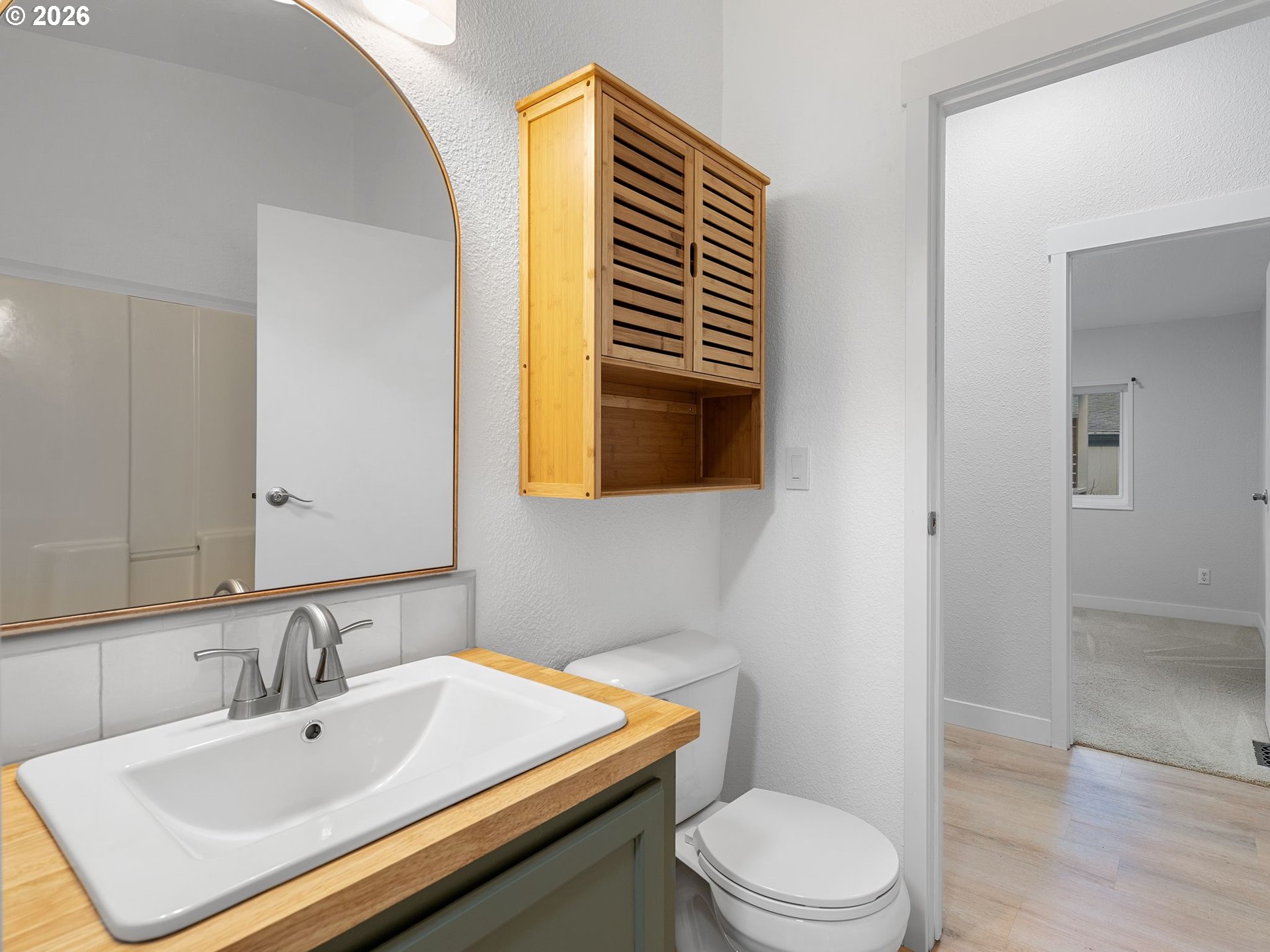 15768 Southeast Powell Boulevard, Unit 12 Portland, OR 97236 - Photo 16 of 31 a bathroom with a sink a toilet and mirror
