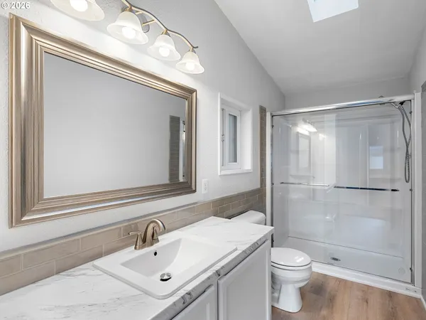a bathroom with a sink mirror toilet and shower