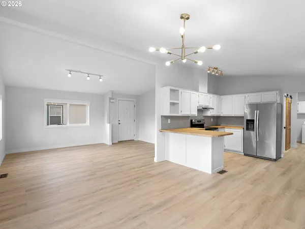 a kitchen with stainless steel appliances kitchen island a refrigerator sink and cabinets