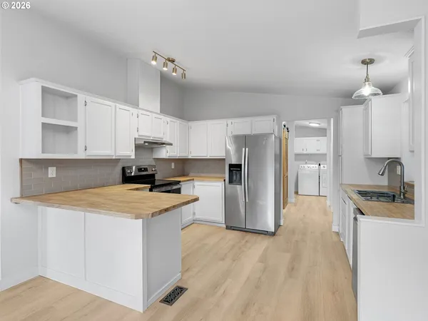 a kitchen with stainless steel appliances a stove refrigerator sink and cabinets