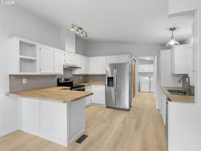 a kitchen with stainless steel appliances a stove refrigerator sink and cabinets