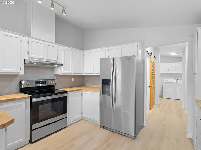 a kitchen with stainless steel appliances a stove a refrigerator and a sink