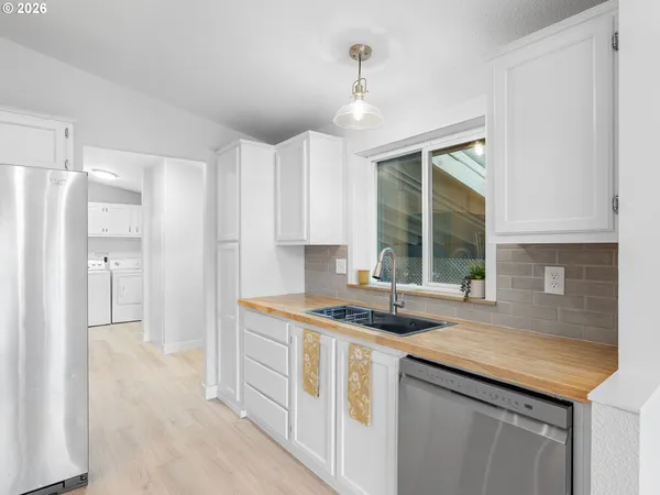 a kitchen with stainless steel appliances granite countertop a sink and a refrigerator