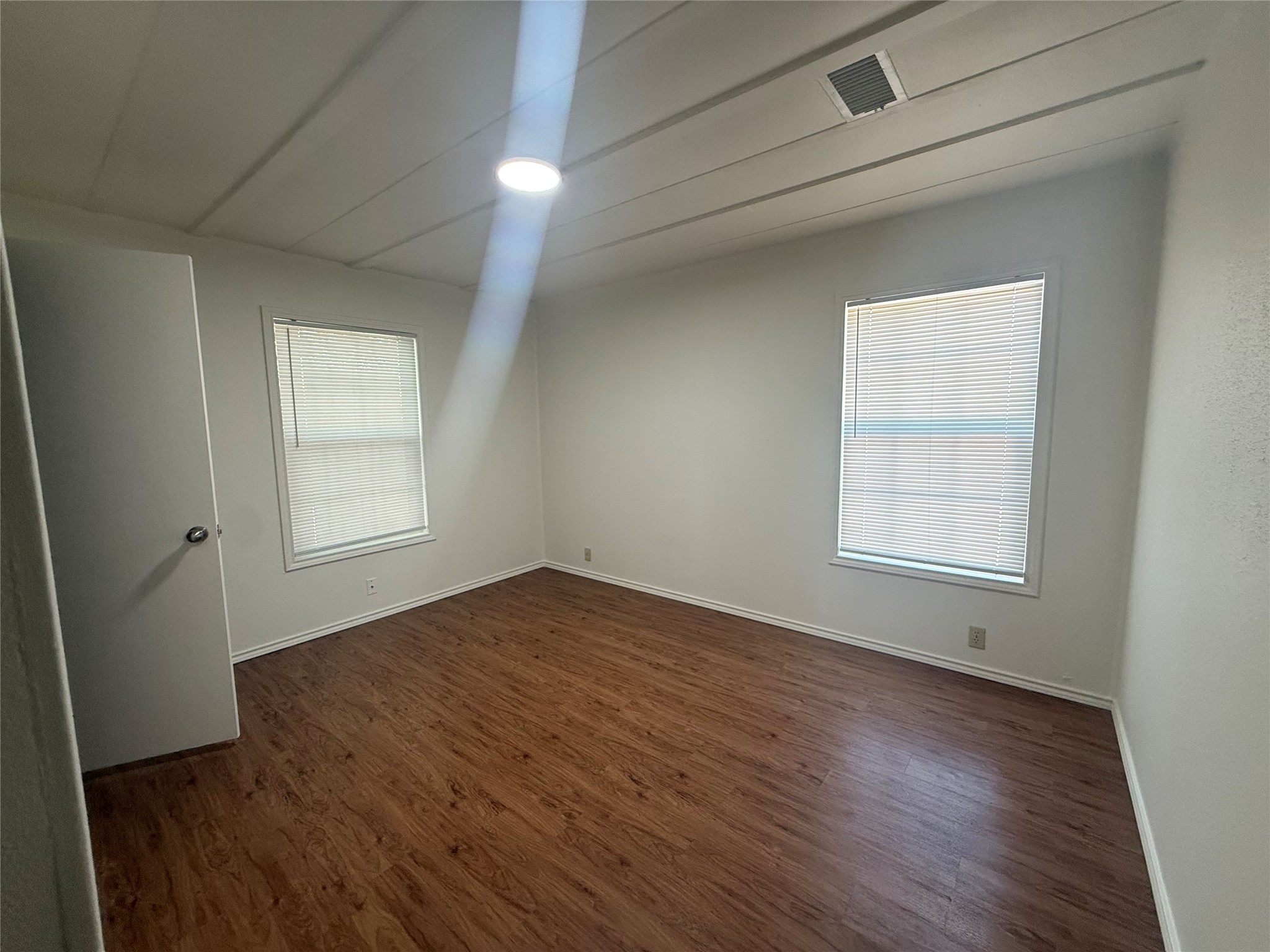 23393 Nameless Road, Unit 112 Leander, TX 78641 - Photo 5 of 16 Warm wood flooring pairs with clean white walls to create a versatile bedroom space.