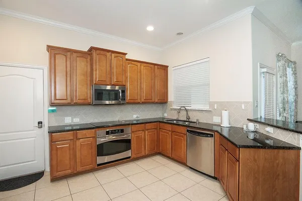 a kitchen with stainless steel appliances granite countertop a sink stove and cabinets