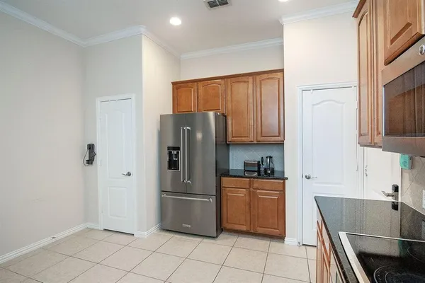 a kitchen with granite countertop a refrigerator and a stove top oven