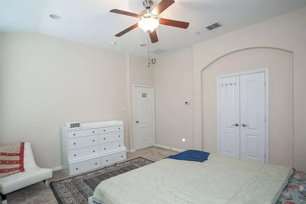 a bedroom with a bed and a ceiling fan
