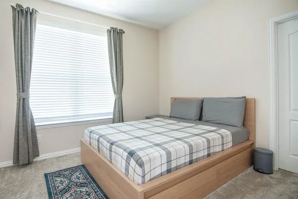 a large bed sitting in a bedroom next to a window