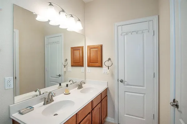a bathroom with a sink a light fixture and a mirror