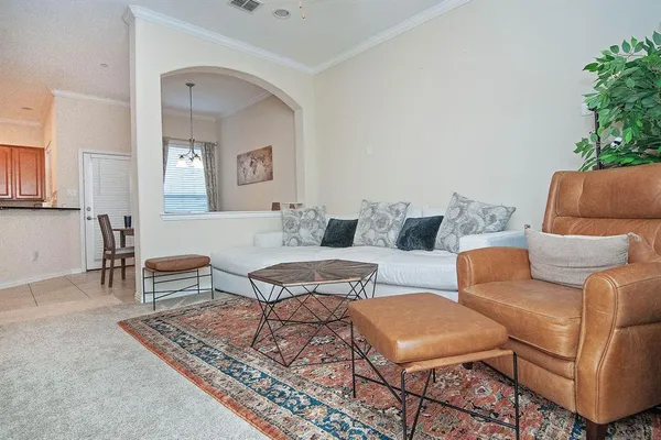 a living room with furniture and a potted plant