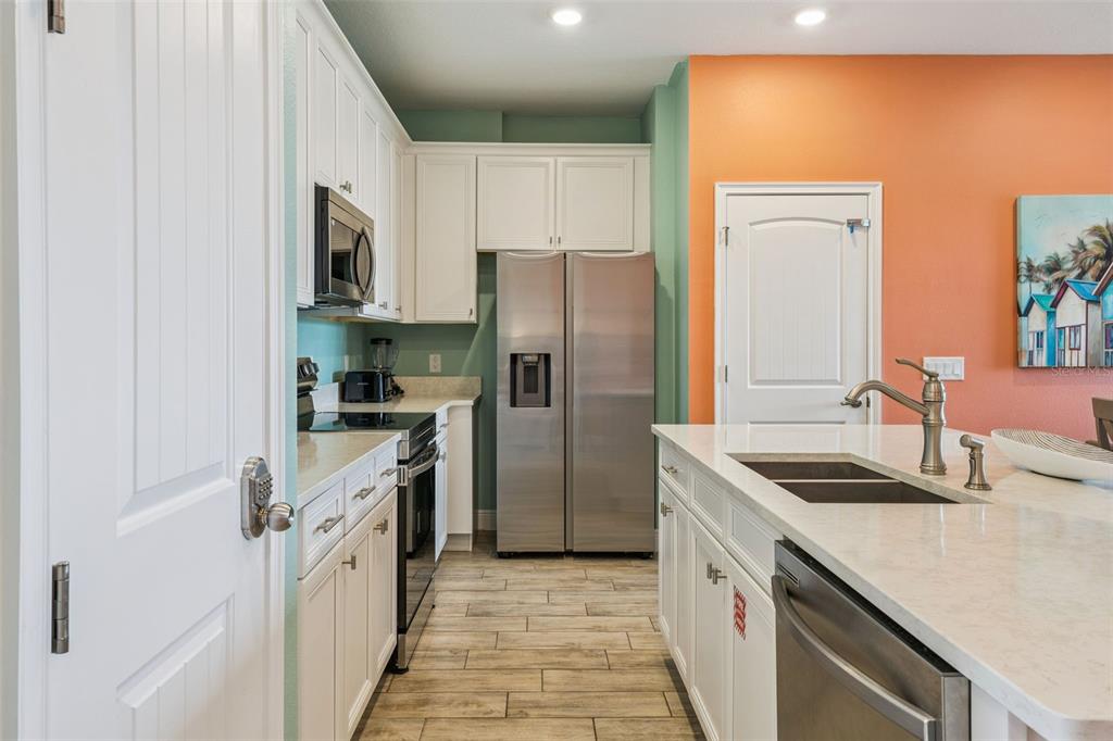 2949 Caribbean Soul Drive Kissimmee, FL 34747 - Photo 12 of 88 a kitchen with stainless steel appliances granite countertop a refrigerator and a sink