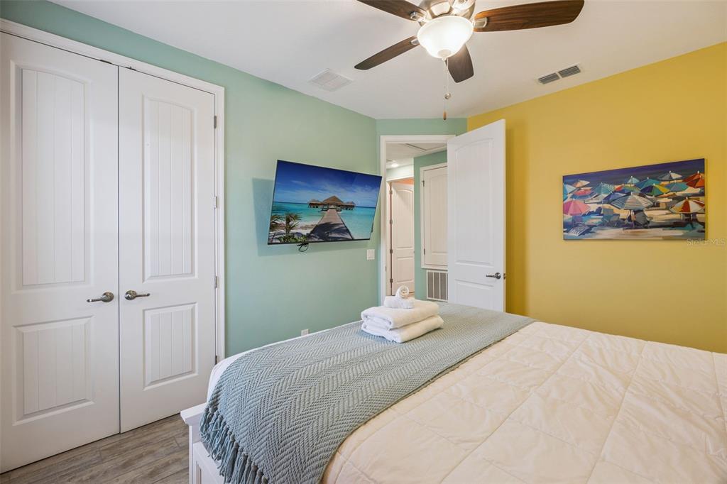 2949 Caribbean Soul Drive Kissimmee, FL 34747 - Photo 27 of 88 a bedroom with a bed and a chandelier