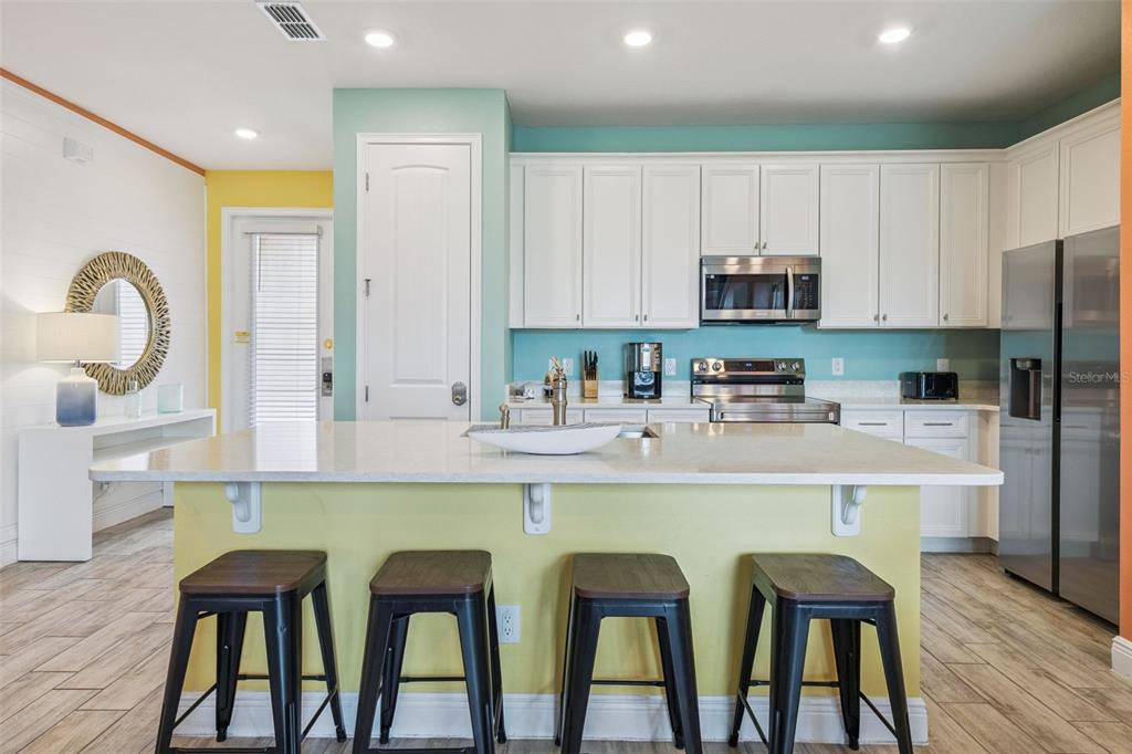 2949 Caribbean Soul Drive Kissimmee, FL 34747 - Photo 9 of 88 a kitchen with stainless steel appliances granite countertop a table chairs microwave and sink