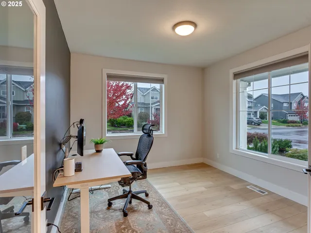 a view of a workspace with furniture and a window
