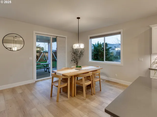 a dining room with furniture a chandelier and wooden floor