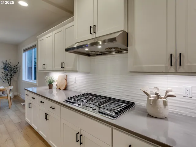 a kitchen with stainless steel appliances a sink a stove and cabinets