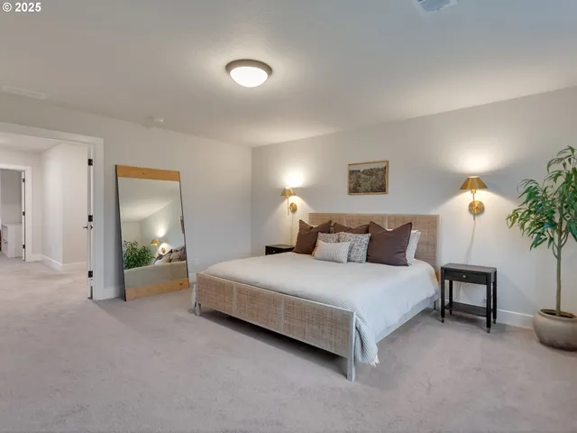 a spacious bedroom with a bed and a potted plant