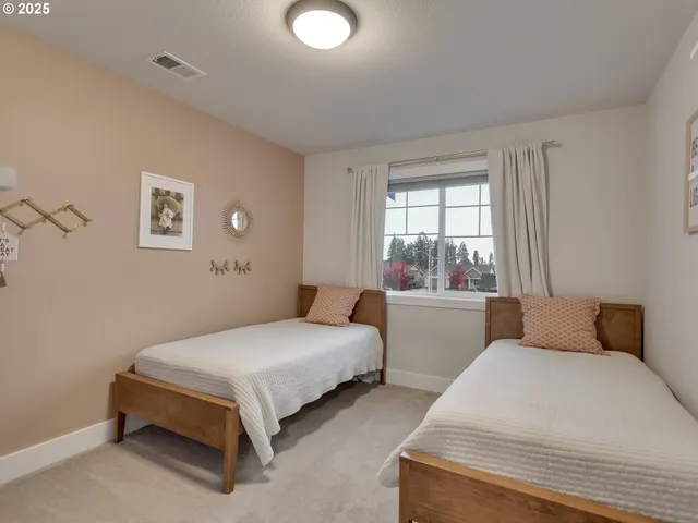 a bedroom with two beds and window