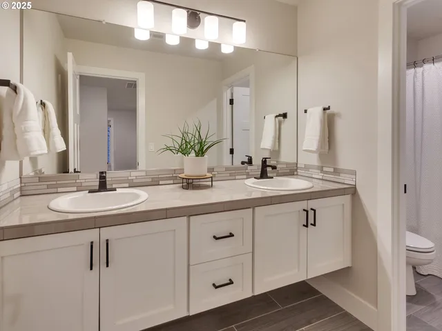 a bathroom with a double vanity sink and a mirror