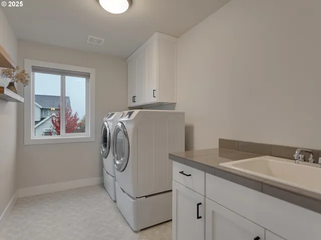 a utility room with cabinets washer and dryer