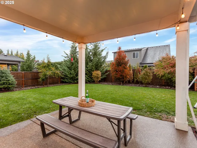 a view of a patio with a table chairs and a yard