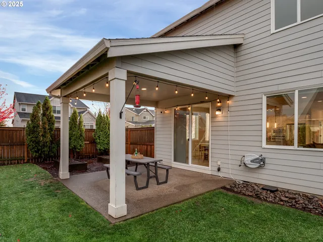 a view of a chair and table in backyard of the house