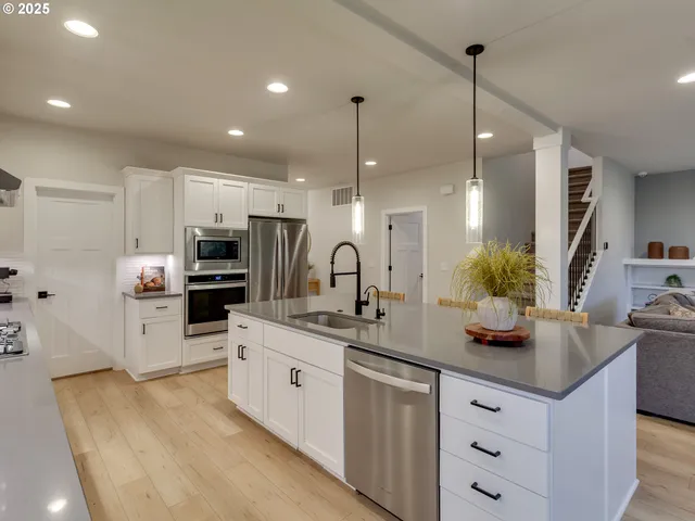 a kitchen with kitchen island granite countertop a sink a counter top space appliances and cabinets