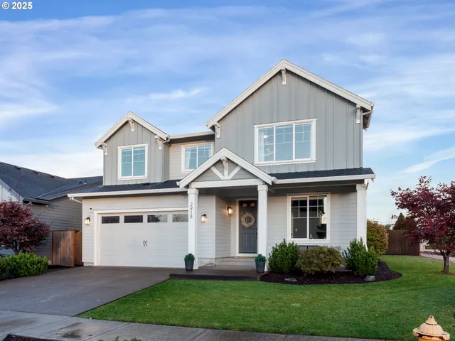 a front view of a house with a yard and trees