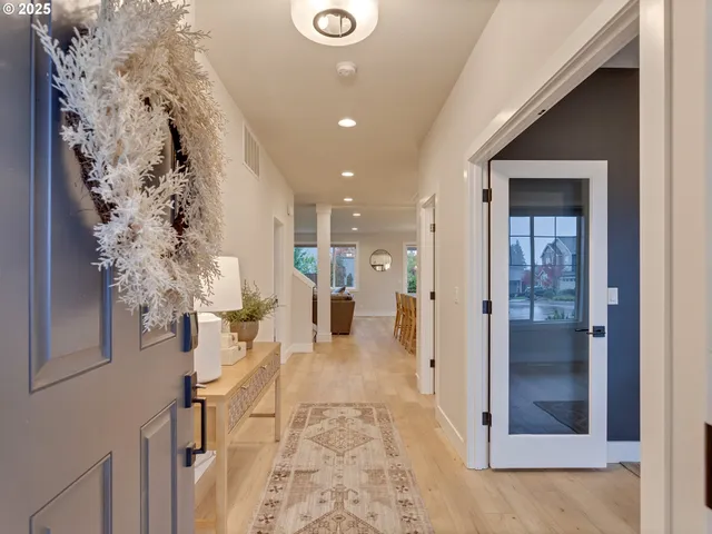a view of a hallway with wooden floor and living room
