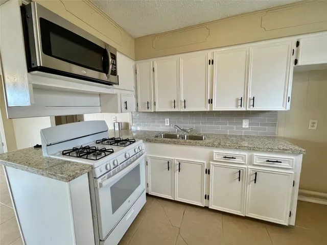 a stove top oven sitting inside of a kitchen