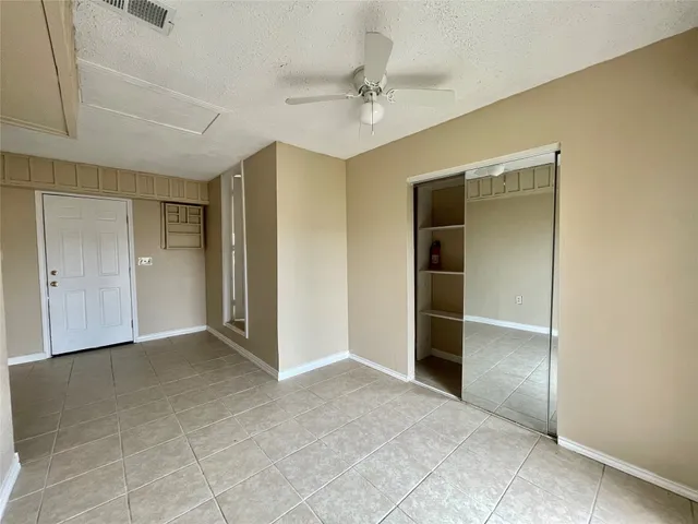 a view of an empty room with a ceiling fan