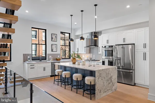 a kitchen with granite countertop a stove a sink a dining table and chairs